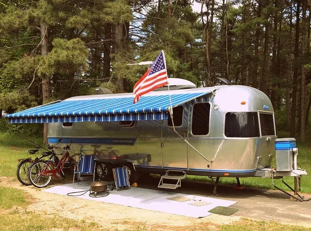 A blue striped side arm trailer awning