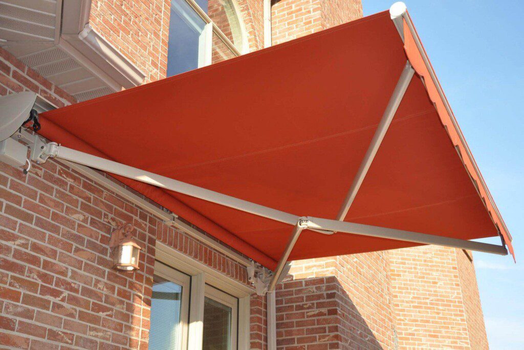 An orange retractable awning with cross arm kit