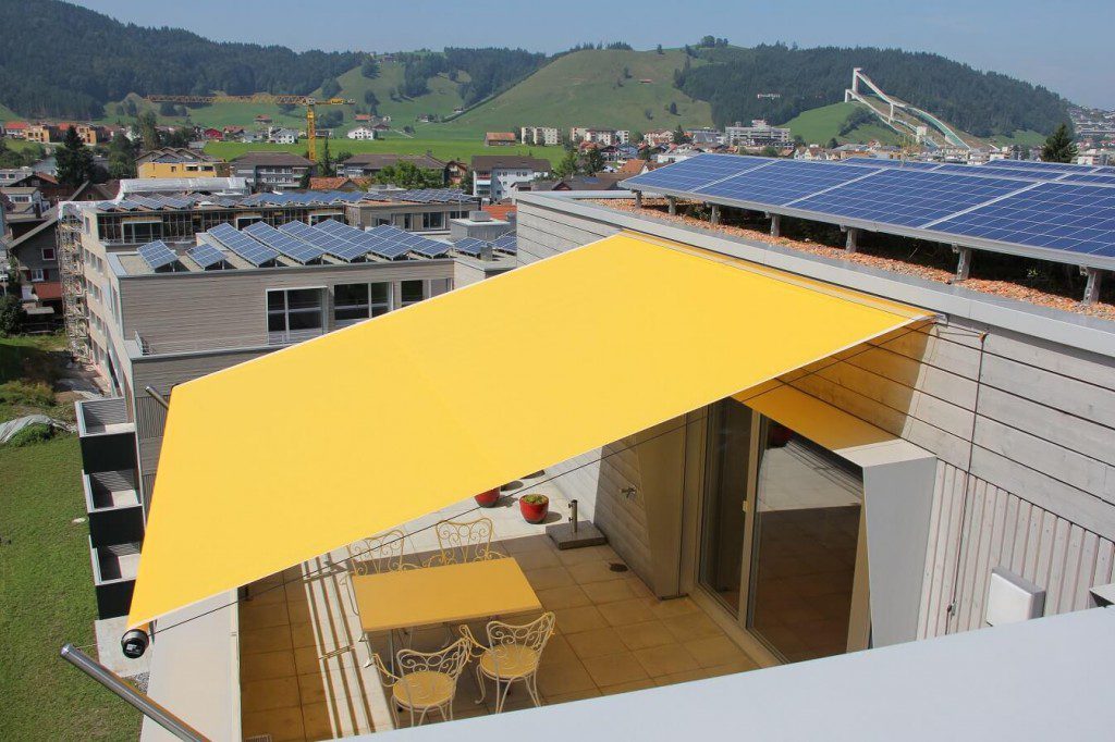 A yellow retractable awning over a backyard